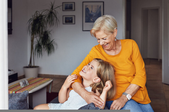 Oma und Enkelin zusammen in einem Wohnzimmer