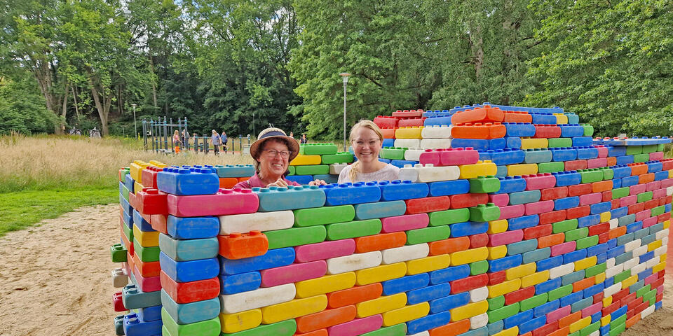 Zwei frauen in einem Park hinter riesigen Legosteinen