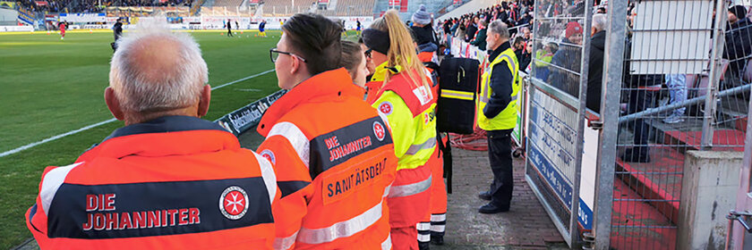 Ehrenamtliche Helfer des Sanitätsdienstes bei einer Absicherung eines Fußballspiels.