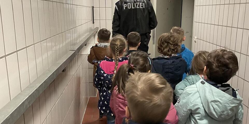 Kinder gehen hinter Polizisten her