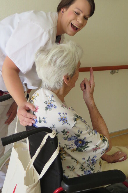 Pflegerin mit Patientin im Rollstuhl