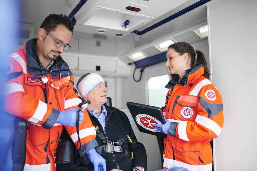 Ein Patient wird von zwei Sanitätern im Rettungswagen versorgt