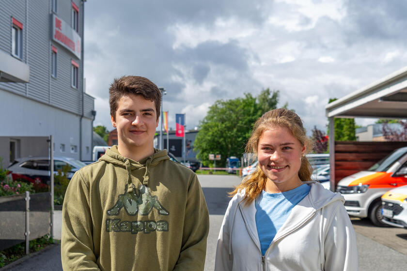 Mika Constantz und Fiona Röttger sind Freiwilligendienstleistende in der Ersten Hilfe. Sie stehen auf dem Hof der Dienststelle in Lübeck.