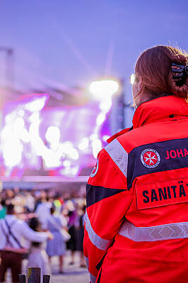 Eine Johanniterin engagiert sich ehrenamtlich im Sanitätsdienst auf einem Konzert. 