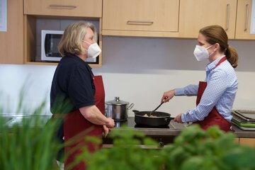 Zwei Damen mit Maske am Kochen 