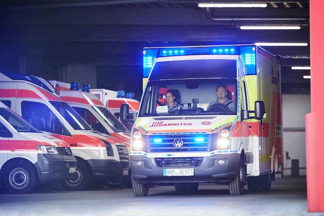 Rettungswagen fährt mit Blaulicht aus der Halle