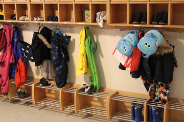 Kinderjacken, Rucksäcke und kleine Hausschuhe in allen Farben zieren die Garderobe der Kita am Wieter.