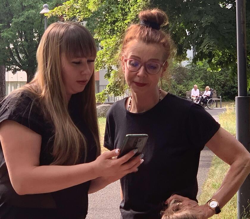 Zwei Frauen, die gemeinsam auf ein Handy gucken