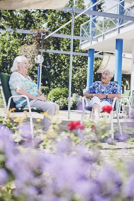 Zwei Bewohnerinnen sitzen im Garten des Johanniter-Pflegewohnhaus Haus Kielwein