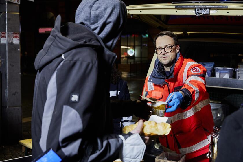 Ehrenamtliche der Kältehilfe in Bremen versorgen Obdachlosen mit warmer Mahlzeit.