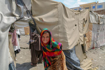 Ein Mädchen steht vor einer provisorischen Hütte in einer der informellen Siedlungen Kabuls