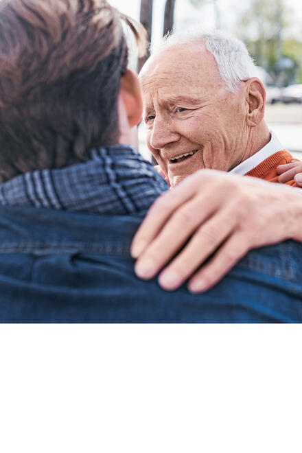 Älterer Mann legt jüngerem dankbar lächelnd die Hand auf die Schulter.
