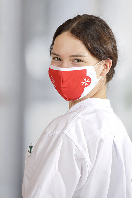 Eine Johanniter-Mitarbeiterin mit einer Corona-Schutzmaske.