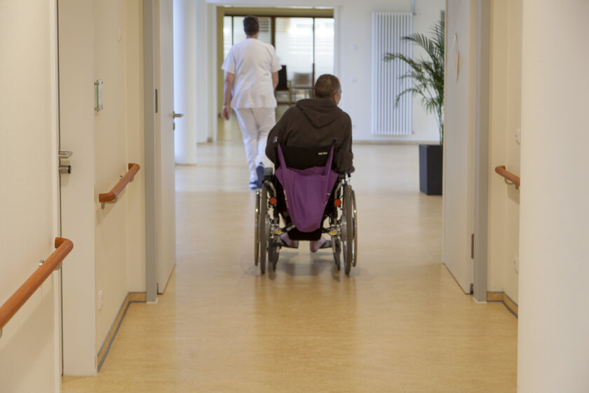Patient im Rollstuhl auf dem Gang der Johanniter-Ordenshäuser Bad Oeynhausen