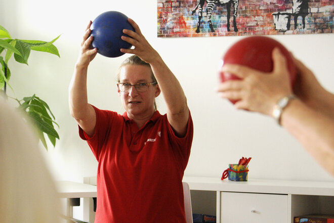Lara Henne, Leiterin des Quartierstreffs im Q4 und ehemalige Sportstudentin zeigt die sportlichen Übungen mit einem Gymnastikball.
