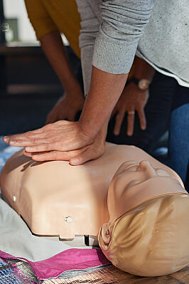 Kursteilnehmerinnen eines Erste-Hilfe-Kurses der Johanniter üben an einer Reanimationspuppe die Herzdruckmassage.