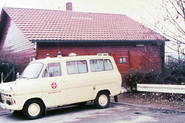 Ein Rettungswagen aus dem Jahr 1964 vor einem Holzhaus