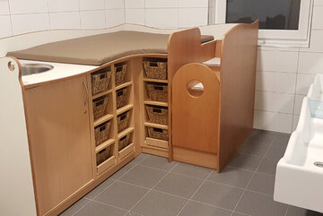 Badezimmer mit Wickeltisch inklusive kleiner Schubladen zum Aufbewahren von Wechselkleidung für die Kinder.