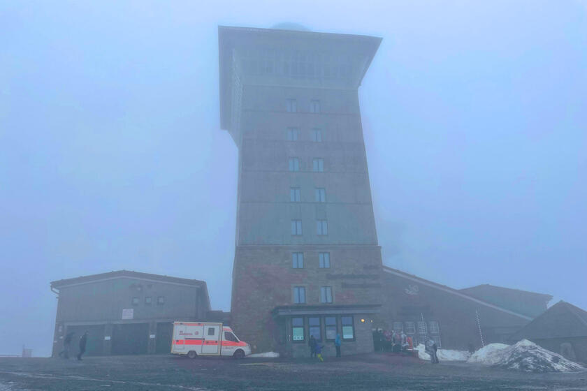 Der Gipfel des Brockens im Nebel. davor ein Johanniter-Rettungswagen.