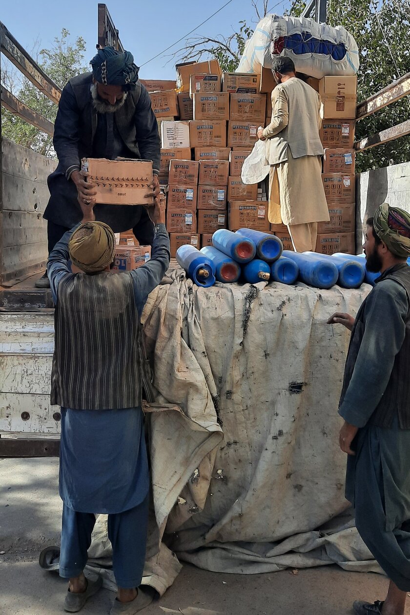 Männer laden Kisten von einem LKW