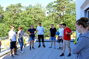 Eine Gruppe von Jugendlichen spielt unter Anleitung eines jungen Erwachsenen im Johanniter-Jugend-Polo Ball