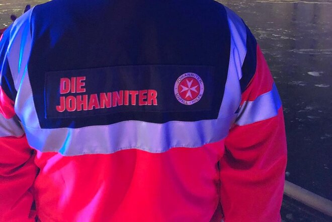 Johanniter Katastrophenhelfer von hinten in Einsatzkleidung.