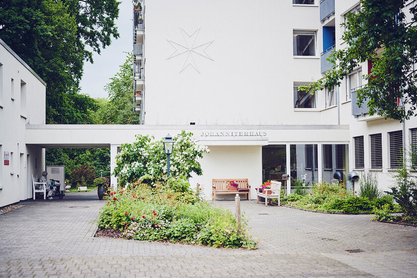 Auf dem Vorplatz des Einganges Johanniterhaus Bremen stehen Gartenbänke zur Nutzung gemeinsamer Treffs der Bewohner.