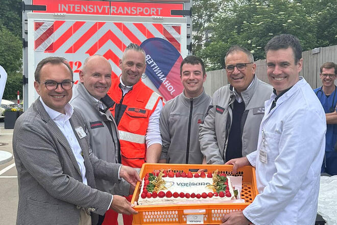 Vertreter der Johanniter, des Klinikum Frankfurt Höchst und der Branddirektion Frankfurt halten gemeinsam eine große Torte mit dem Schriftzug varisano.