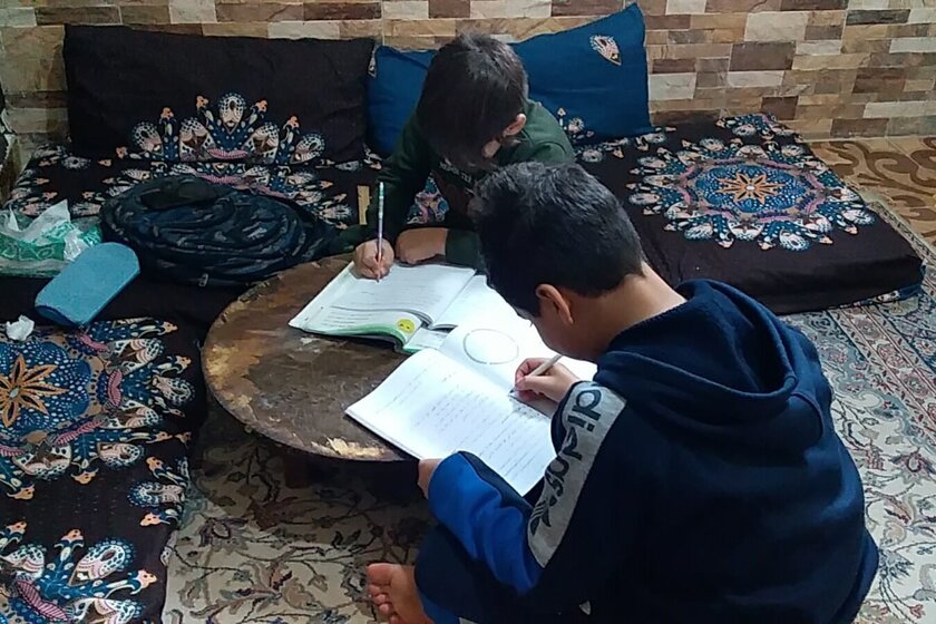 Ein Junge macht Hausaufgaben am Wohnzimmertisch