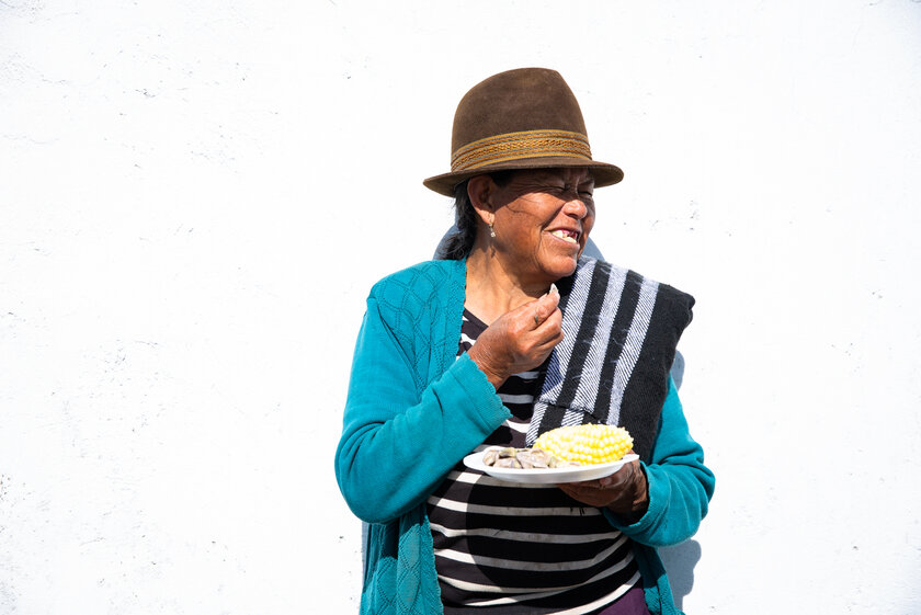 Eine Frau die glücklich Mais isst.