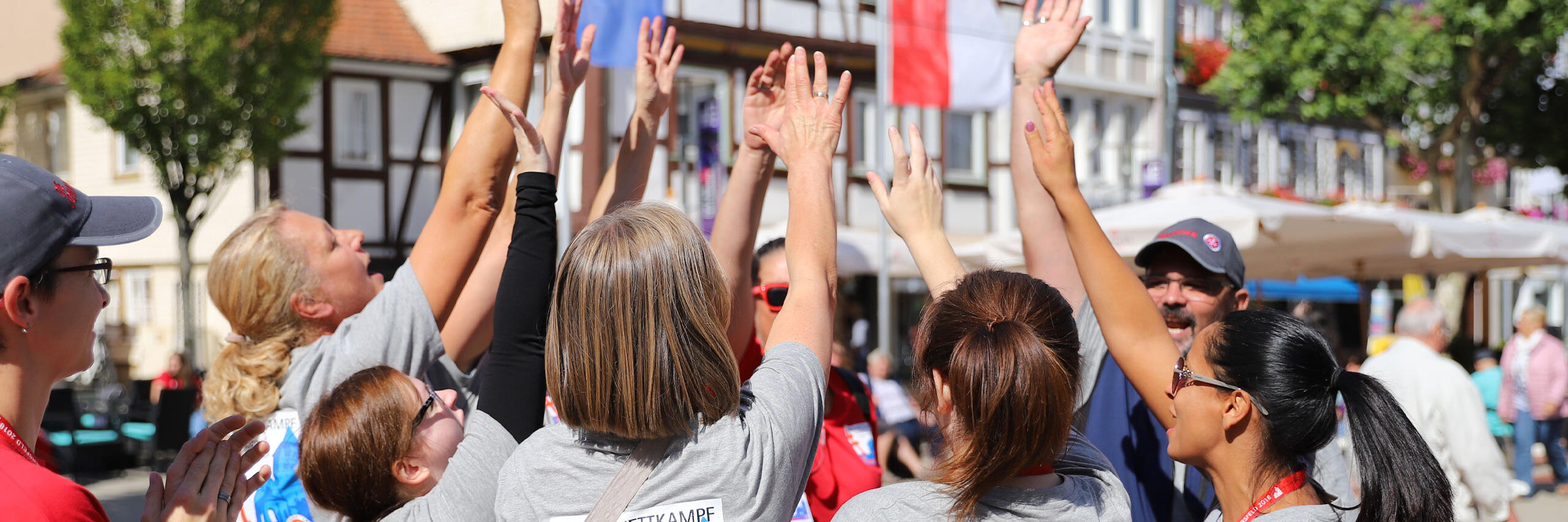 Mehrere Erzieher der Johanniter geben sich ein high-five, um sich für die bevorstehenden Aufgaben beim Landeswettkampf 2018 in Bad Hersfeld anzufeuern.