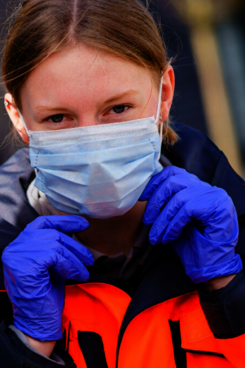 Eine Mitarbeiterin der Johanniter-Unfall-Hilfe mit einer medizinischen Atemmaske.