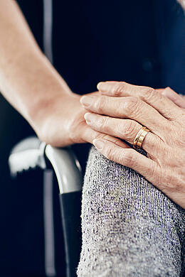Eine Pflegerin spendet einer Seniorin im Rollstuhl Trost.