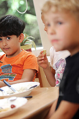 Drei Kinder beim gemeinsamen Essen.