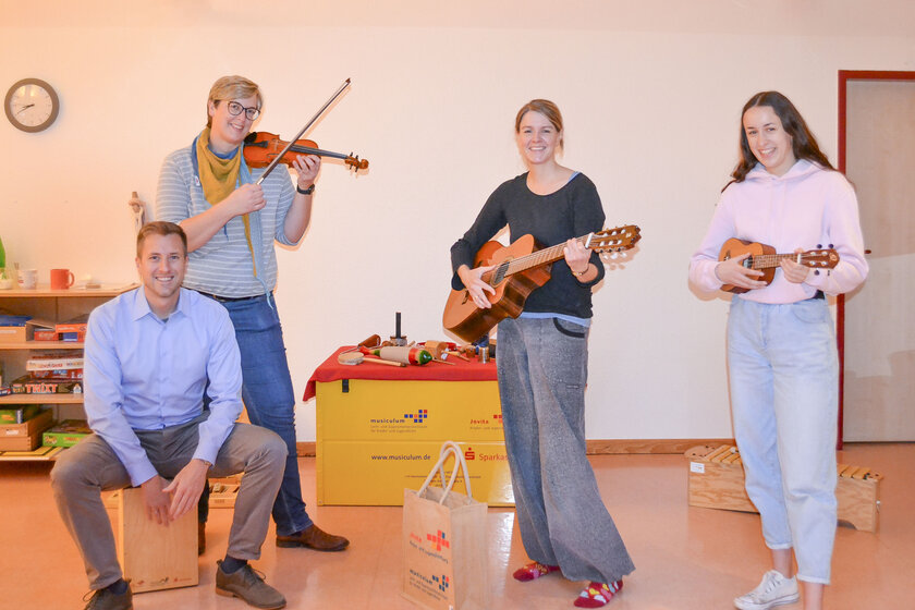 Florian Friedrich (Sparkasse), Annika Holmer (Leitung Johanniter-Kinderhaus Wilde 13), Mareike Irsigler und Emely Burchardt (musiculum MOBIL) zeigen die mitgebrachten Instrumente.