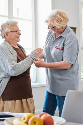 Johanniter-Pflegerin hilft älterer Dame im eigenen Zuhause 