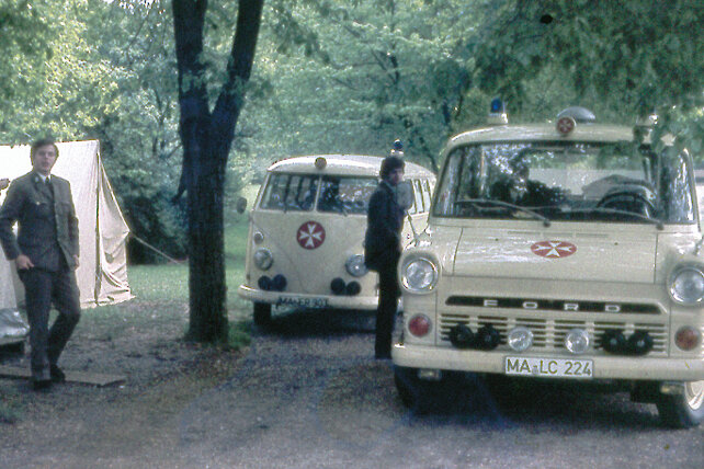 Sanitäter und Fahrzeuge vor einem Sanitätszelt im Jahr 1964.