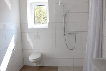Blick in eines der Badezimmer mit begehbarer Dusche. 