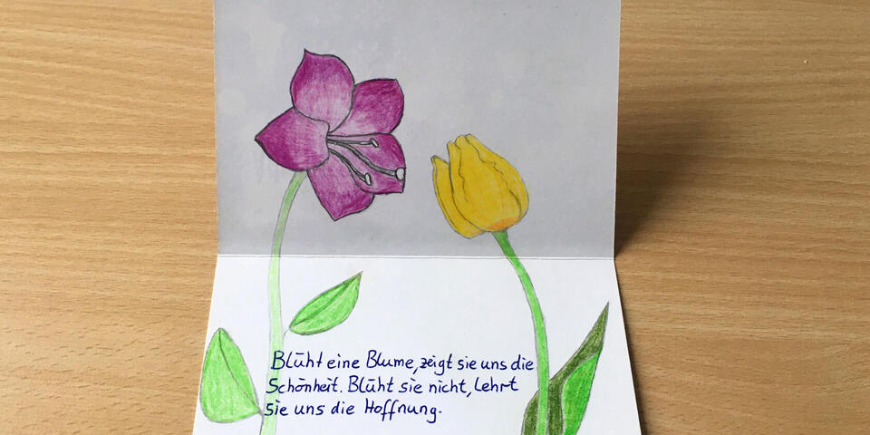 Eine Karte mit Wünschen, liebevoll mit gemalten Blumen dekoriert